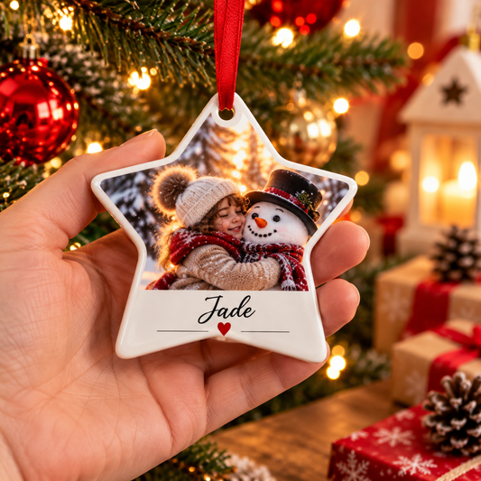 Étoile de Noël en céramique tenue en main, avec la photo d'une petite fille serrant un bonhomme de neige et le prénom Jade